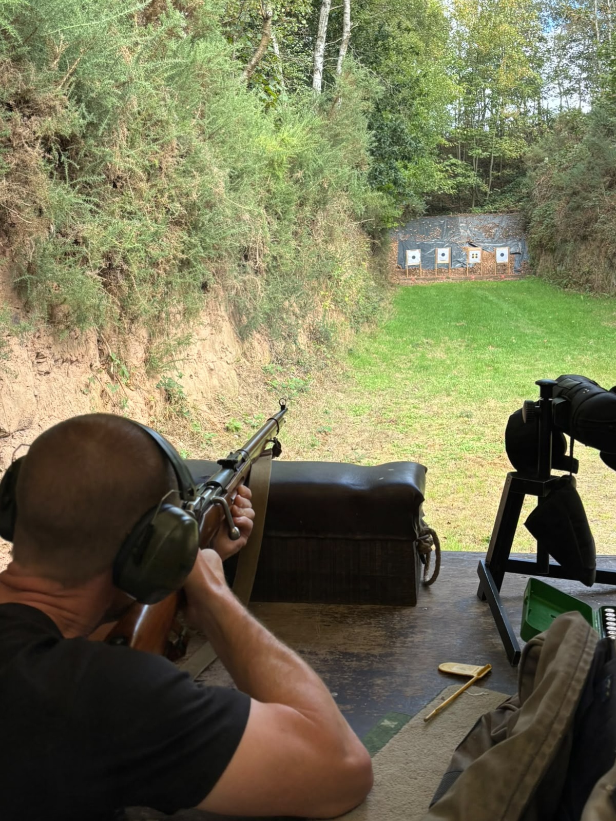 Member at a shooting bench overlooking woodland targets — enlarge photo
