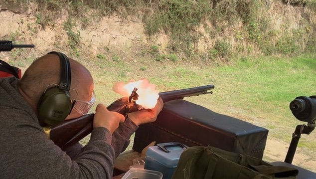 Member aiming a rifle at the range — enlarge photo